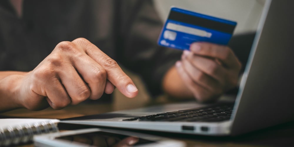 Businessman holding credit card and typing on laptop for online shopping and payment makes a purchase on the Internet