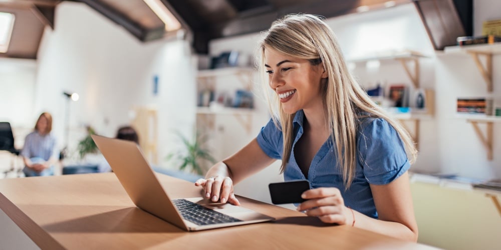 Happy young woman doing e-shopping.