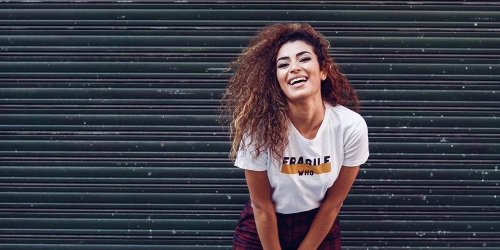 Smiling arab girl in casual clothes in the street.