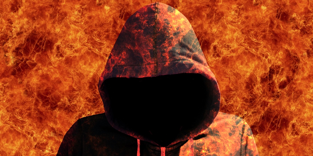 Man with a hoodie walking through the fire devil halloween concept