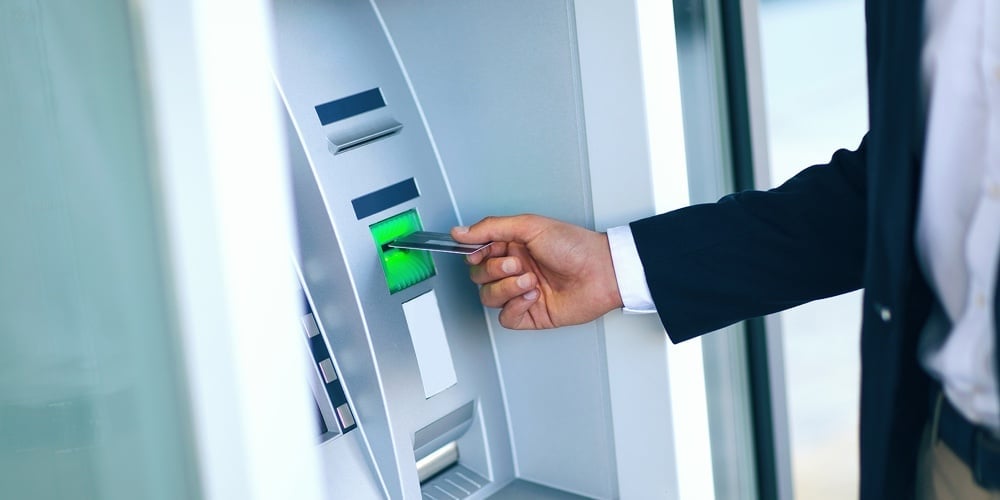 Close-up Of Person Using Credit Card To Withdrawing Money From Atm Machine