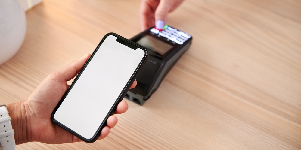A Customer In A Cafe Makes A Contactless Payment Using An Online Application On His Phone. Close-up