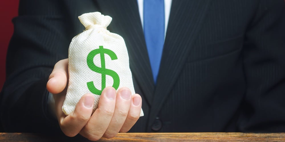 A Man Holds Out A Bag Of Money. Provision Of Money On Credit