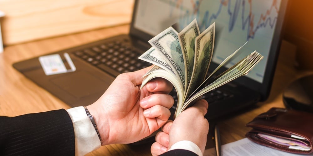 bigstock-A-Man-In-A-Suit-Counts-The-Mon-234235018
