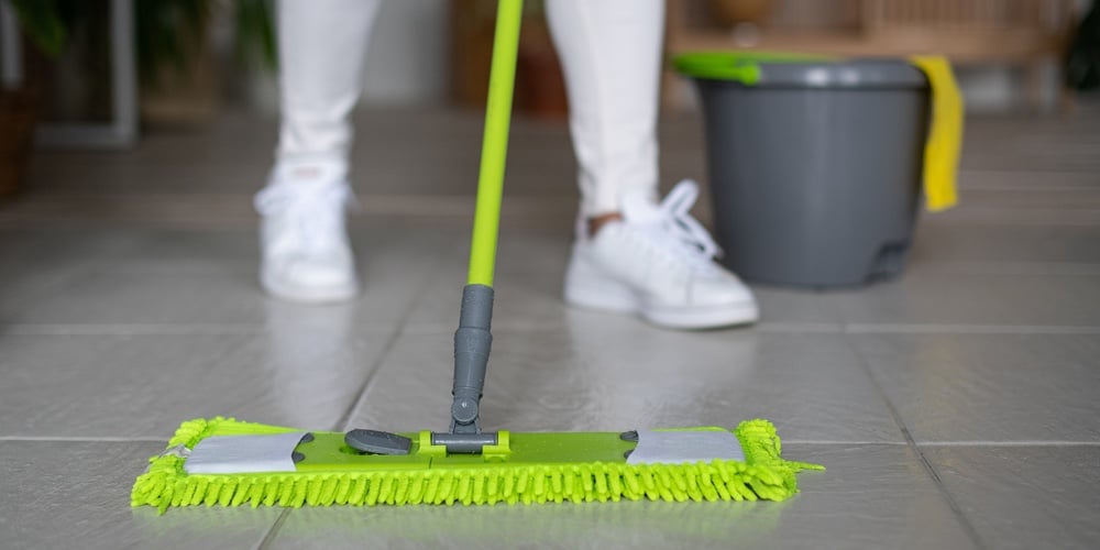 A Professional Cleaner Washes The Floor With A Mop. A Green Rag Rubs The Floor. Cleaning Of Apartmen
