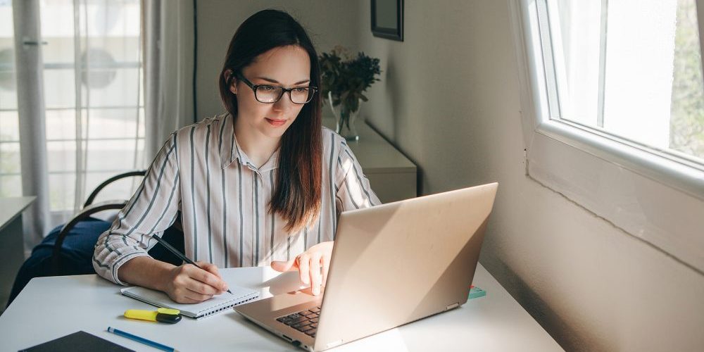 A Young Beautiful Student Girl Does Homework Or Writes A To-do L