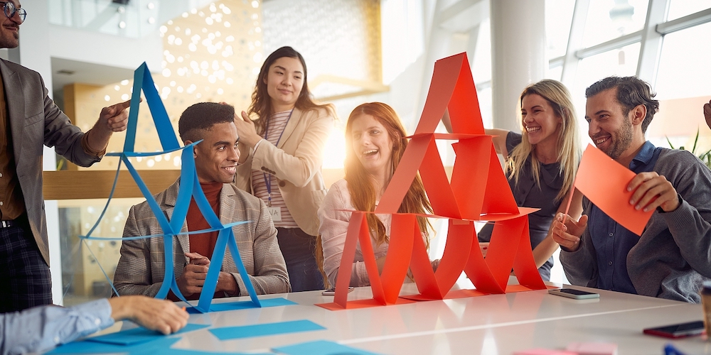 A group of young business people is enjoying team building games in a cheerful atmosphere during a b