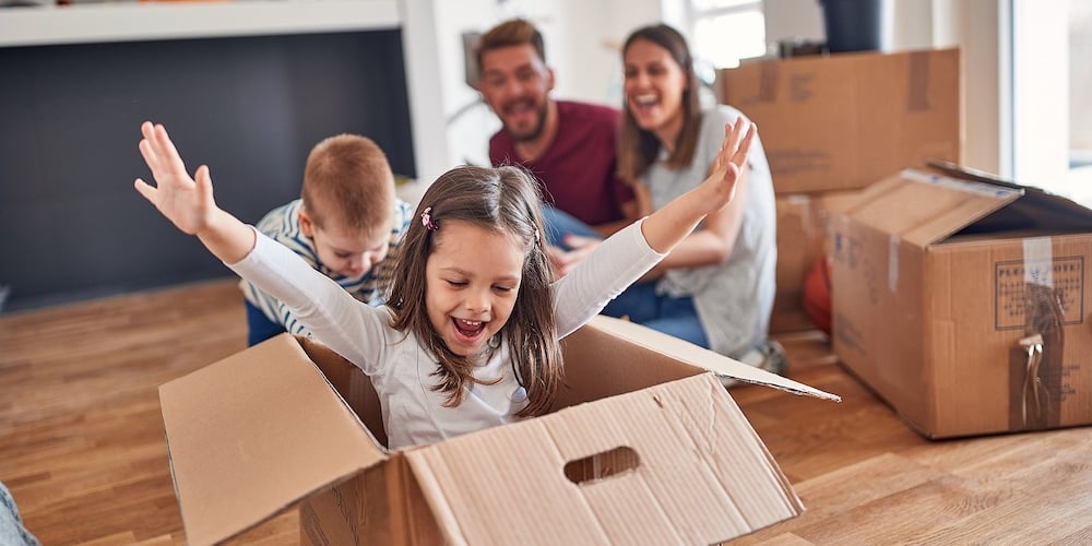 A young family is playing in a cheerful atmosphere in the new home they have just moved in. Home