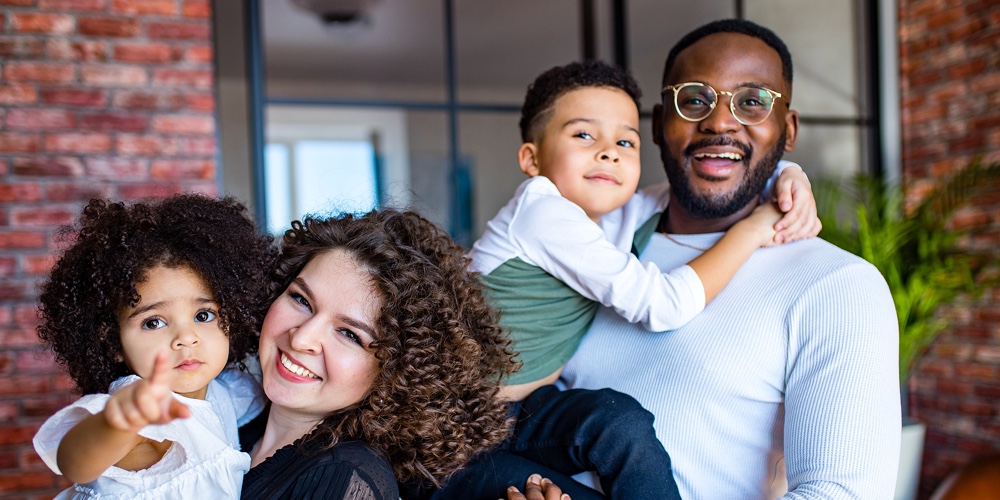 Afro American Mixed-raced Family Looking At Camera In Cozy Summer Day Light In Living Room