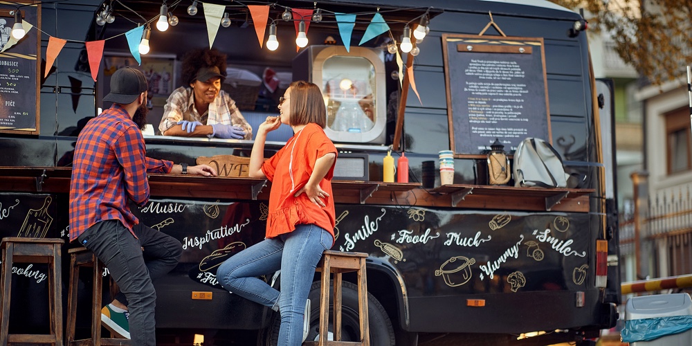 Afro american food truck employee taking orders from customers