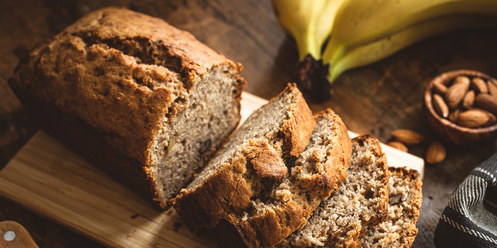 Banana Bread Loaf Sliced On Wooden Table. Wholegrain Banana Cake With Nuts