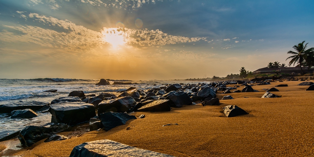 Beach With Red Sand And Black Rocks With A Beautiful Sunset In Congo Town