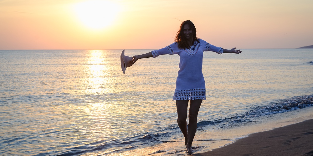 Beautiful Woman Smiling On Beach. Happy People Lifestyle. Woman Smiling In Sunset With Arms Outstret