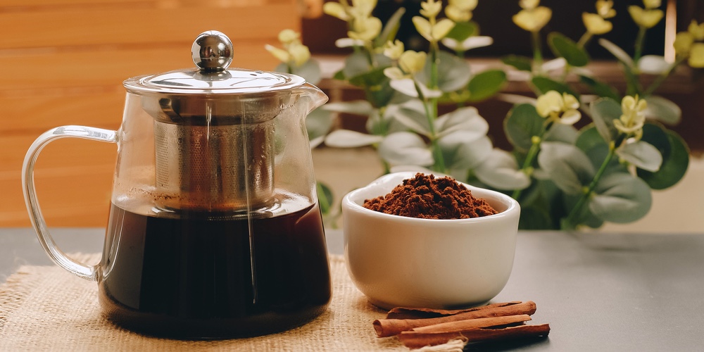 Black Coffee And Cinnamon Sticks. Aromatic Coffee From Freshly Ground Coffee Grounds.