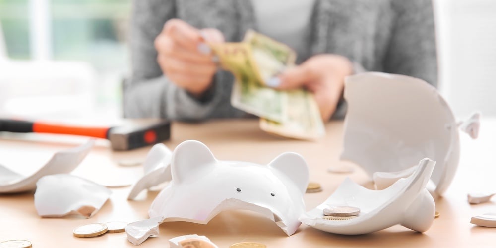 bigstock-Broken-piggy-bank-with-coins-a-207384805