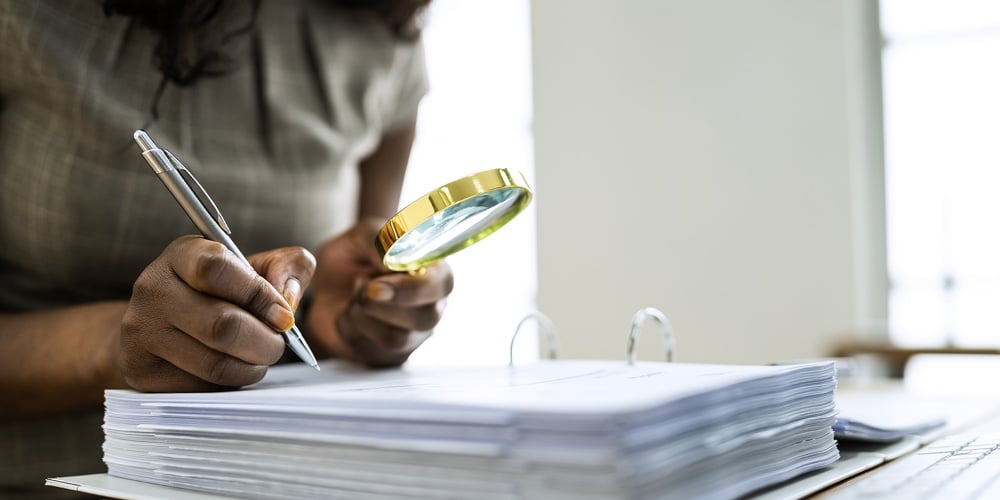 Business Fraud Investigation. Auditor Using Magnifying Glass To Investigate