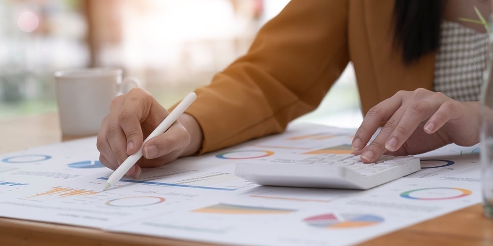 Business Woman Using Calculator To Calculate Financial Report