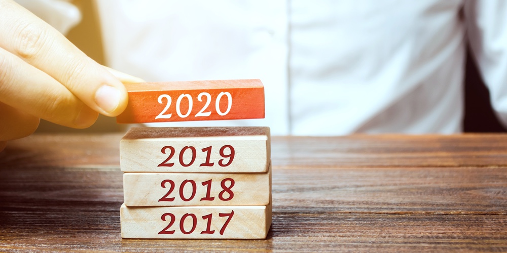 Businessman Builds Wooden Blocks 2020. The Concept Of The Beginning Of The New Year. New Goals. Next