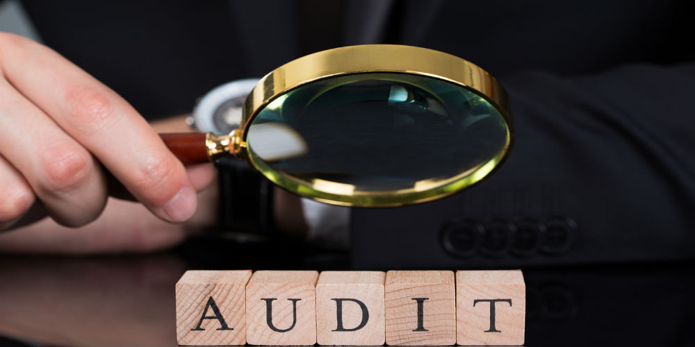 bigstock-Businessman-Examining-Audit-Bl-72328465
