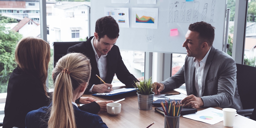 Businessman Executive In Group Meeting Discussion With Other Businessmen And Businesswomen In Modern