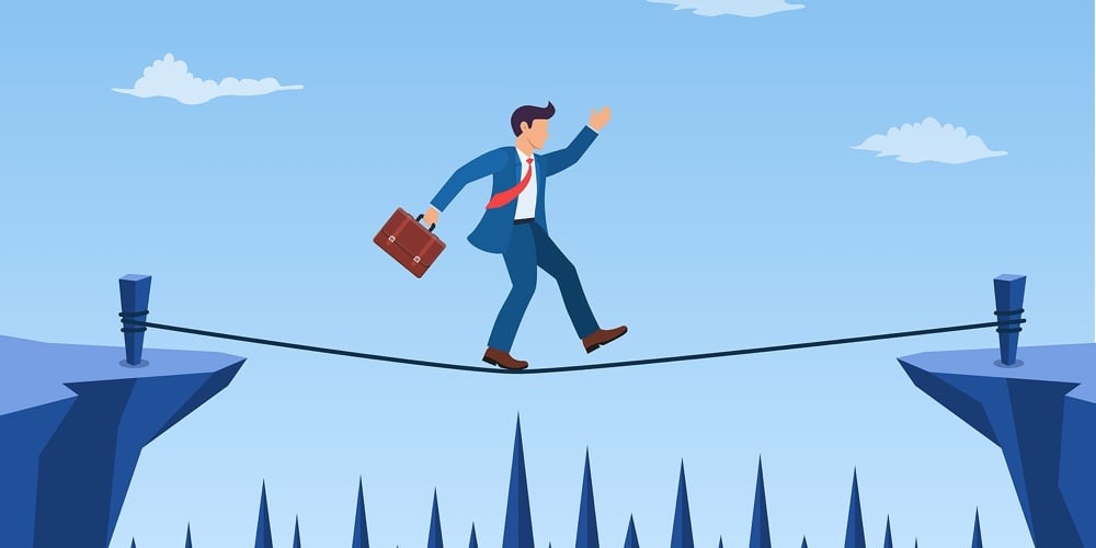 Businessman Is Walking A Tightrope Across The Gap Between The Rocks. Business Concept Risk And Dange