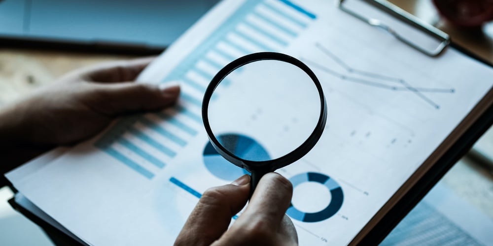 Businessman Looking Through A Magnifying Glass To Documents. Business Assessment And Audit. Magnifyi