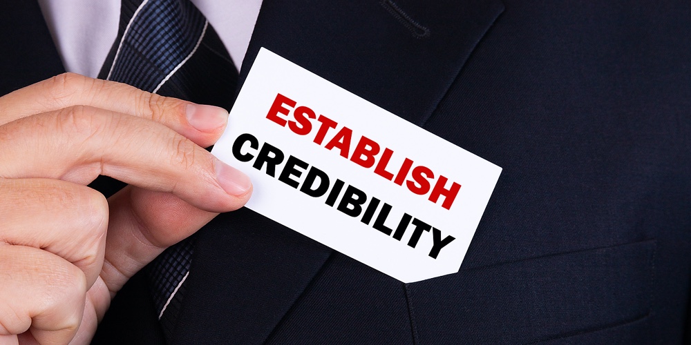 Businessman Putting A Card With Text Establish Credibility In The Pocket