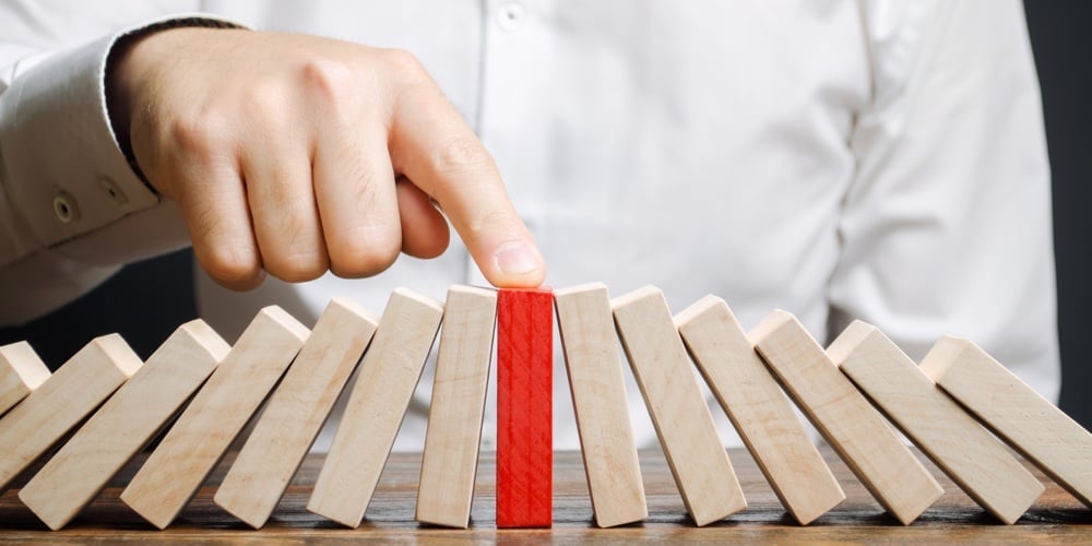 bigstock-Businessman-Stops-Collapse-Dom-308715640