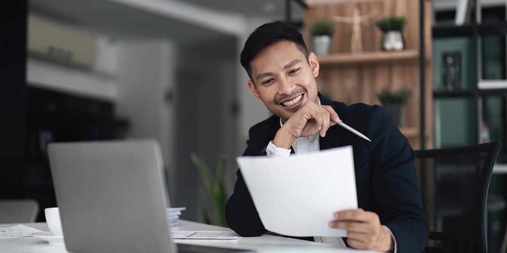Businessman Using Laptop Computer In Office. Happy Middle Aged Man