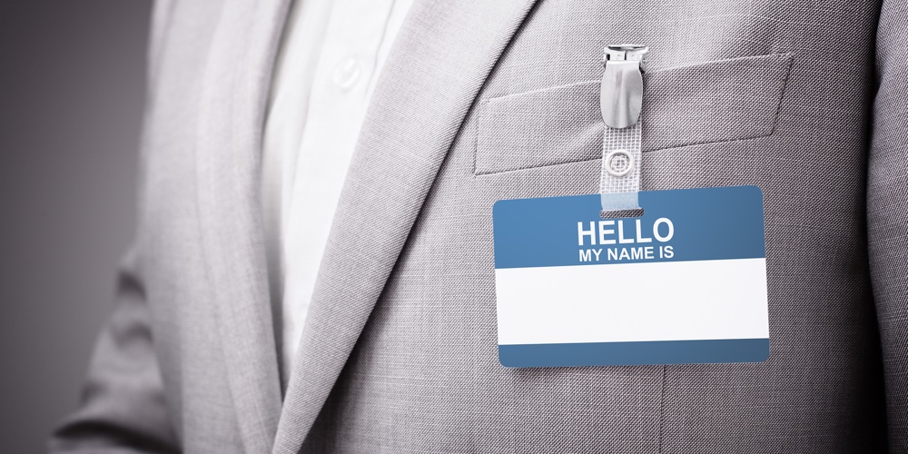 Businessman at an exhibition or conference wearing a Hello my name is security identity name card or