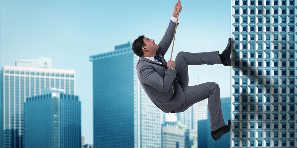 Businessman in challenge concept climbing skyscraper