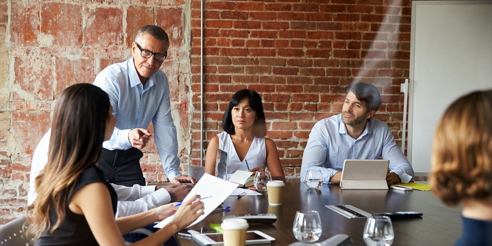 Businesspeople Meeting In Modern Boardroom Through Glass