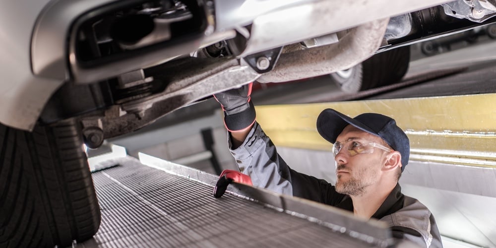 Car Maintenance Service Making By Caucasian Professional Vehicle Mechanic. Vehicle Undercarriage Che