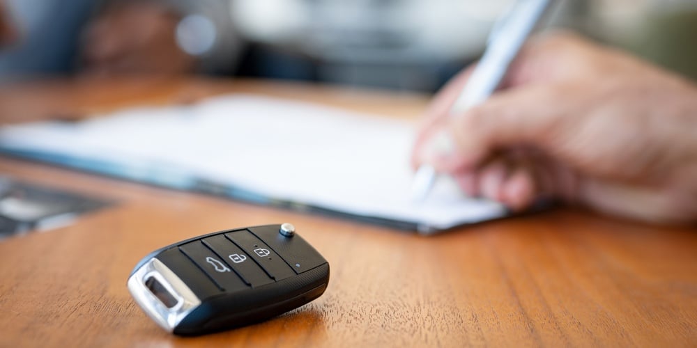 bigstock-Car-keys-on-desk-with-man-sign-297904318