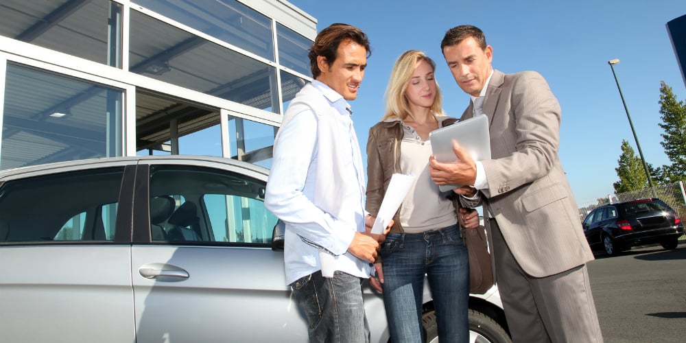 bigstock-Car-seller-with-couple-looking-23701790