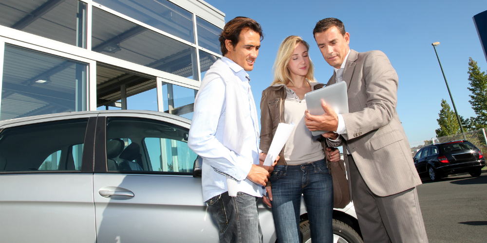 bigstock-Car-seller-with-couple-looking-23701790