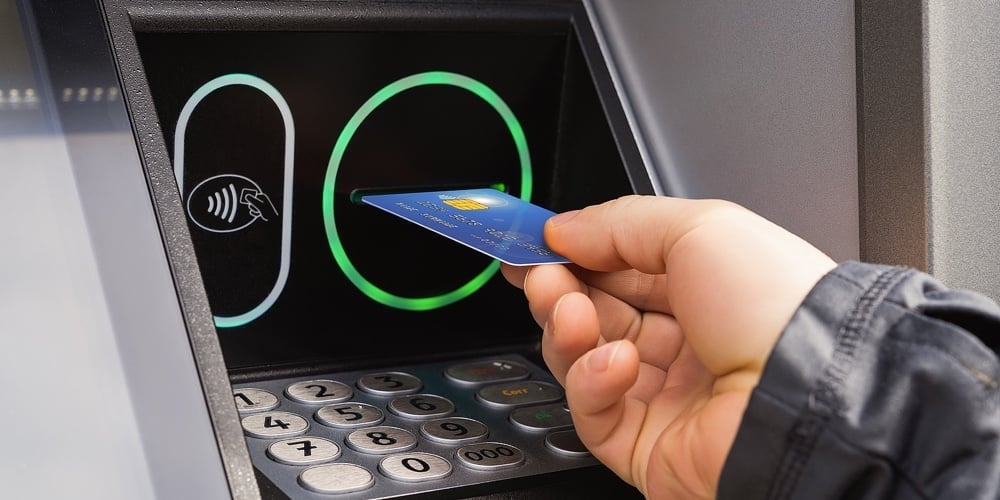Caucasian Person Hand Inserts A Credit Card Into An Atm Machine. Receiving Money From An Atm During