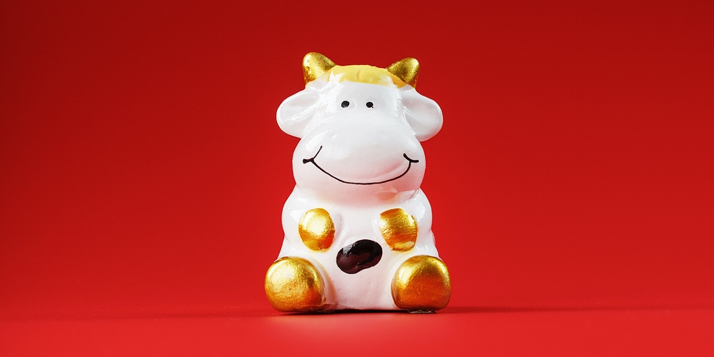 Christmas Toy Of A Cow Made Of Ceramic On A Red Background. 2021 Year Of The Bull