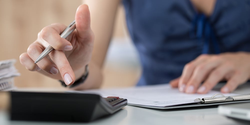Close Up Of Female Accountant Or Banker Making Calculations