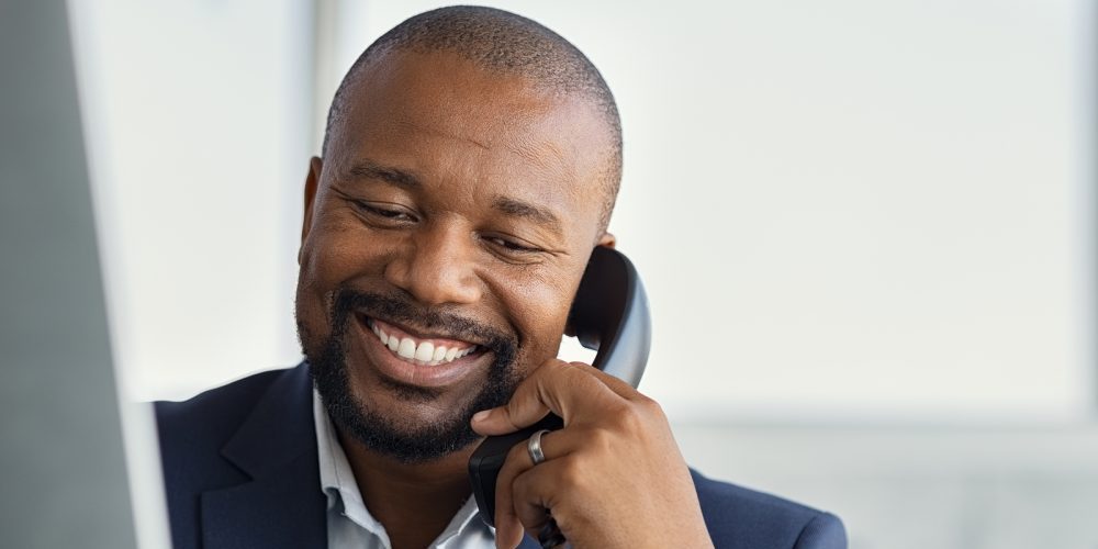 Close up face of mature businessman working on computer and talk