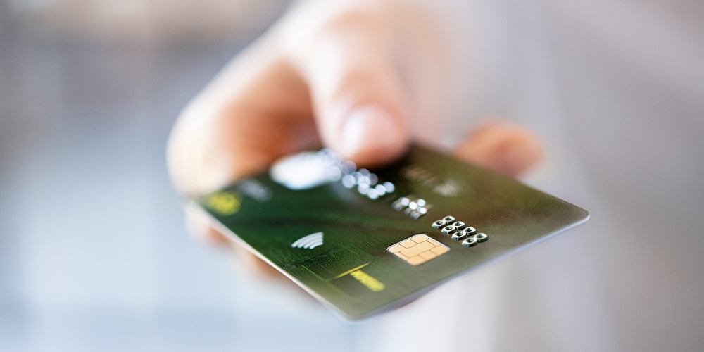 Close up of woman hand showing credit card. Detail of girl giving credit card for electronic payment