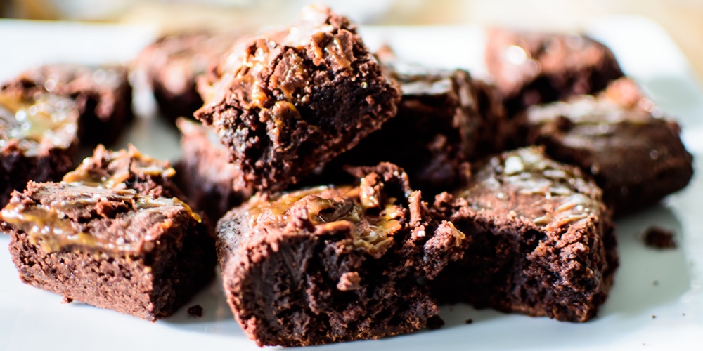 Closeup Of Rich Dark Chocolate Cake Brownies On Plate With Salted Caramel Topping Cut Into Chocolate
