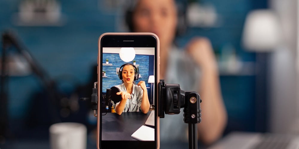 Closeup Of Smartphone Recording Woman Influencer On Live Stream Podcast. Vlogger Talking In Front Of