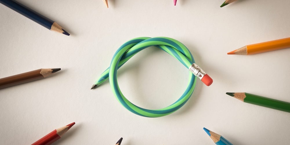 Colored Pencils With One Flexible Pencil On White Background. The Concept Of Flexibility In Decision