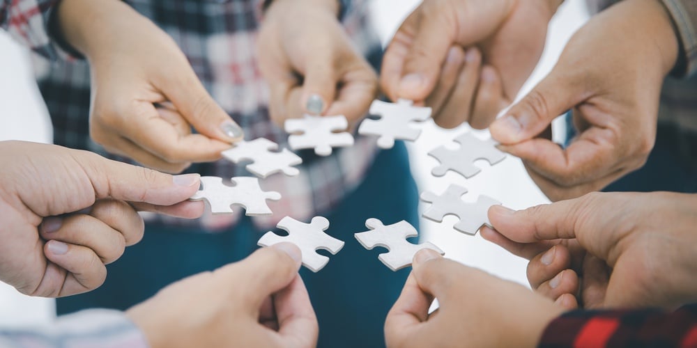 Concept Of Finding Solution. Close Up  People Assembling Jigsaw Puzzles In Work Meeting Banner With