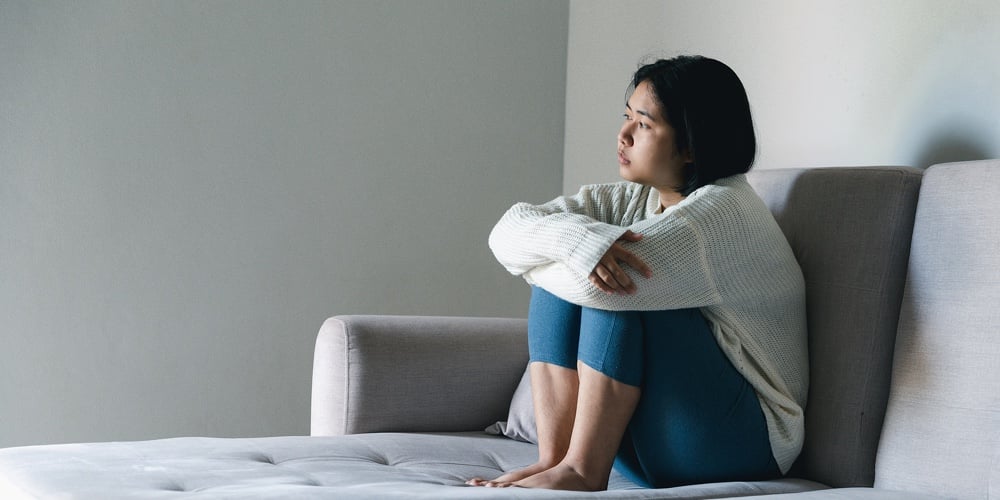 Concept Of Sad Teenage Girl Depression. Upset Teenage Girl Sitting At Window Indoors. Anxiety Young