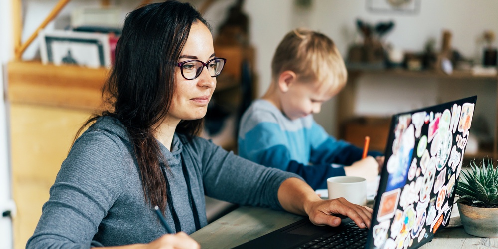 Concept Of Work From Home And Home Family Education. Mom And Son Are Sitting At The Desk. Business W