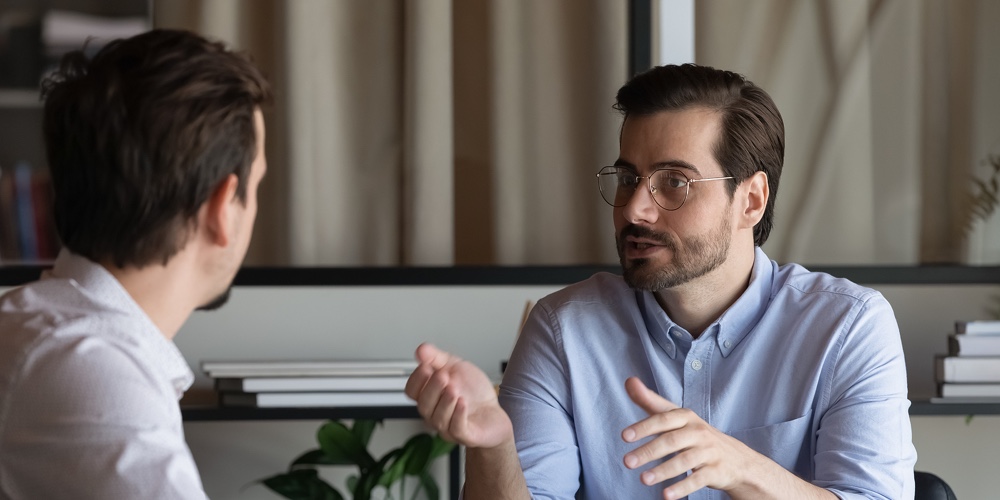Confident Manager In Glasses Consulting Client At Meeting In Office