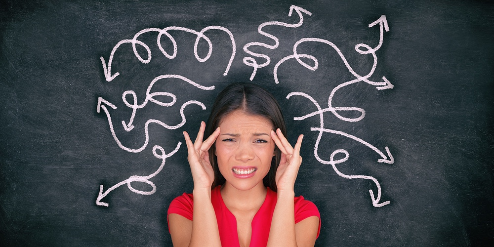 Confused woman confusion illustrated on blackboard with chalk drawing of arrows going everywhere aro