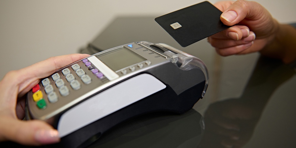 Contactless Nfc Payment By Credit Card And Via Pos Terminal. Focus On The Customer’s Hand Holding A